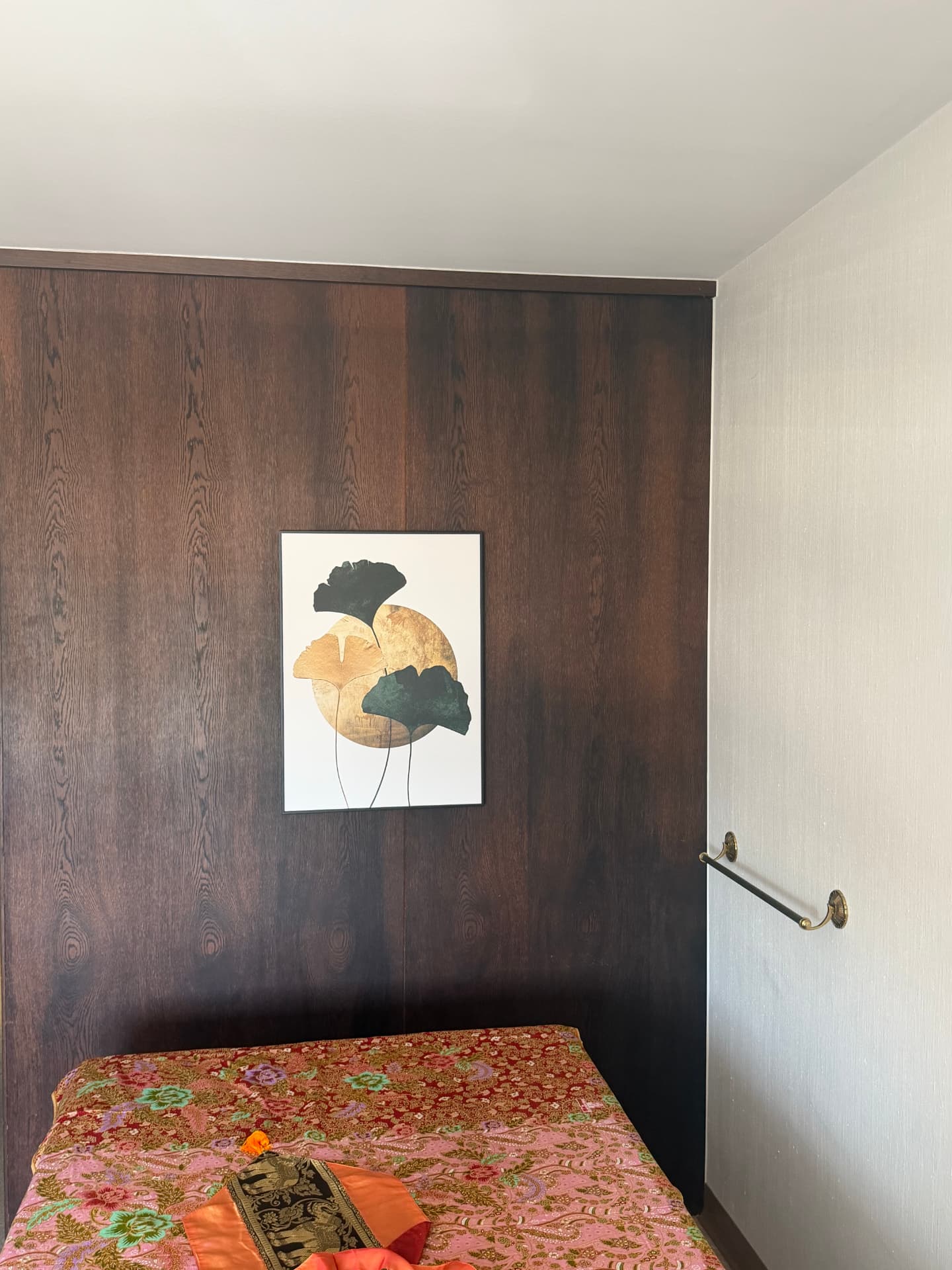 Ruhiger Raum mit Ginkgo-Bild an dunkler Holzwand